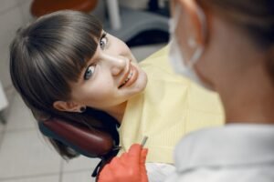 A smiling woman sitting in a dental chair.